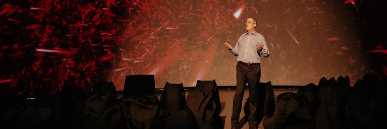 Deinococcus radiodurans resists and feeds off radioactivity. Yves Brun presents at The Poetry of Bacteria, a public conference he organized in April 2022 as a collaboration between the Society for Arts and Technology and the Université de Montréal. © Society for Arts and Technology
